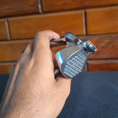 Stainless steel garlic press held in hand (2) Durable Garlic Press – Easy Everyday Crushing