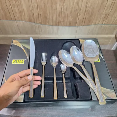 Hand holding AVD 36 piece cutlery set knife from place setting