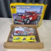 Decool 31010 - Parts Bag Held Hand holding Decool 31010 parts bag with box in background