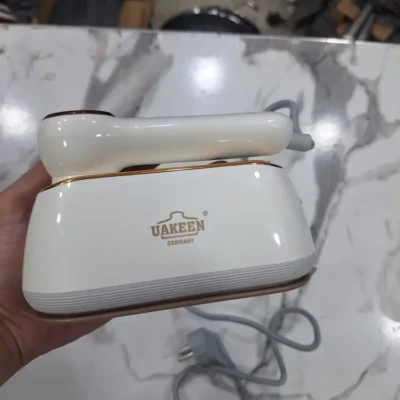 Uakeen Mini Steam Iron - Handle Button Detail Uakeen mini steam iron rose gold handle power button close-up